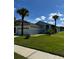 Charming single-story home featuring a two-car garage, well-manicured lawn, and palm trees at 1623 Bridgeview Cir, Orlando, FL 32824