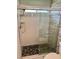 Tiled shower with pebble floor, glass door, and chrome fixtures at 1623 Bridgeview Cir, Orlando, FL 32824
