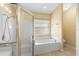 Bright bathroom features a soaking tub, a window providing natural light, and a glass shower at 1669 Slash Pine Pl, Oviedo, FL 32765