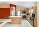 Well-lit kitchen features stainless steel appliances, wooden cabinets, island and a tiled floor at 1669 Slash Pine Pl, Oviedo, FL 32765