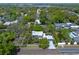 Aerial view of a modern home surrounded by mature trees, featuring a pool and well-manicured lawn in a quiet neighborhood at 1970 Laurel Rd, Winter Park, FL 32789
