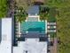 Aerial view showcases a backyard oasis with a pool, outdoor dining area, and lounge chairs surrounded by lush greenery at 1970 Laurel Rd, Winter Park, FL 32789