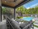 Outdoor living space with covered patio, comfortable seating, and a sparkling pool surrounded by lush landscaping at 1970 Laurel Rd, Winter Park, FL 32789