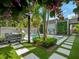 Lush backyard featuring a pool, outdoor kitchen, a privacy fence, and multiple palm trees at 1970 Laurel Rd, Winter Park, FL 32789