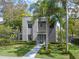 Sophisticated modern architecture featuring a well-kept lawn, manicured greenery, and stately palm trees at 1970 Laurel Rd, Winter Park, FL 32789