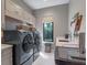 Well-equipped laundry room with modern machines, sink, and ample storage space at 1970 Laurel Rd, Winter Park, FL 32789