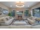 Spacious living room featuring a fireplace, comfortable sofas, and a stylish, modern light fixture at 1970 Laurel Rd, Winter Park, FL 32789