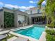 Stylish outdoor living space with a pool, outdoor kitchen, and lush vertical garden perfect for relaxation and entertainment at 1970 Laurel Rd, Winter Park, FL 32789