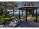Lakeside backyard featuring a beautiful gazebo, wooden walkway, and private dock at 2020 Venetian Way, Winter Park, FL 32789