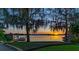 Picturesque backyard with a private dock, beautiful sunset views over the water, and mature trees at 2020 Venetian Way, Winter Park, FL 32789