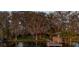Lush backyard featuring a private dock on the water with mature trees and a gazebo at 2020 Venetian Way, Winter Park, FL 32789