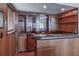 Wood-paneled bar area features glassware cabinets and shelving at 2020 Venetian Way, Winter Park, FL 32789