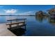 Wooden dock and peaceful lake view on a beautiful day with a partially cloudy blue sky at 2020 Venetian Way, Winter Park, FL 32789