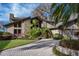 Beautiful home exterior with manicured lawn, stone accents, and a spacious paved driveway at 2020 Venetian Way, Winter Park, FL 32789