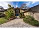 Inviting home exterior with lush landscaping, a stone facade, and a charming blue front door at 2020 Venetian Way, Winter Park, FL 32789