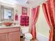 A stylish bathroom with a vessel sink, decorative mirror, and elegant shower curtains at 2055 S Atlantic Ave # 1604, Daytona Beach, FL 32118