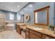 Primary bathroom featuring dual sinks, granite counters, soaking tub, and wood framed mirrors at 2109 E Central Blvd, Orlando, FL 32803