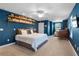 Blue accent wall bedroom with unique wood shelving, large bed, bright lighting and an attached lounge area at 2109 E Central Blvd, Orlando, FL 32803