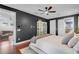 A spacious bedroom featuring dark walls, hardwood floors, a ceiling fan, and a doorway to a living area at 2109 E Central Blvd, Orlando, FL 32803