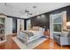 A spacious main bedroom showcases a dark accent wall, hardwood flooring, and serene natural light at 2109 E Central Blvd, Orlando, FL 32803