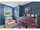 Stylish home office with blue walls, natural light, comfortable chair and classic wooden desk and chair at 2109 E Central Blvd, Orlando, FL 32803