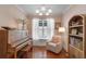 Cozy room features a piano, chair, window, and bookshelf, creating a warm and inviting space at 2109 E Central Blvd, Orlando, FL 32803