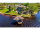 Waterfront home aerial view showing covered boathouse, lush lawn, mature palms, and water frontage at 2112 Shady Ln, Geneva, FL 32732