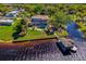 Aerial view of waterfront home featuring lush lawn, mature palms, pool and spa, and private boat dock with covered boathouse at 2112 Shady Ln, Geneva, FL 32732