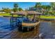 View of boat dock with covered boathouse and boat, offering waterfront access and boat storage at 2112 Shady Ln, Geneva, FL 32732