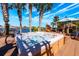 Outdoor hot tub overlooking a scenic lake with a covered area and palm trees, offering a relaxing retreat at 2112 Shady Ln, Geneva, FL 32732