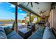 Covered patio features comfortable seating, ceiling fans, and overlooks the backyard pool and waterfront at 2112 Shady Ln, Geneva, FL 32732