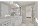 Bright bathroom with double sinks, white cabinetry, large mirror, and a glass-enclosed shower at 2291 Raven Ridge Rd, Minneola, FL 34715