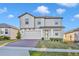 Beautiful two-story home featuring light grey paint, manicured lawn and a brick paver driveway at 2291 Raven Ridge Rd, Minneola, FL 34715