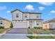 Beautiful two-story home featuring light grey paint, manicured lawn and a brick paver driveway at 2291 Raven Ridge Rd, Minneola, FL 34715