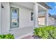 Charming covered front porch with a light teal door and a well maintained landscape at 2291 Raven Ridge Rd, Minneola, FL 34715