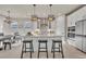 Open concept kitchen featuring modern light fixtures, a large island, and stainless steel appliances at 2291 Raven Ridge Rd, Minneola, FL 34715