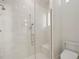 Sleek frameless glass shower featuring marble tile surround and built-in bench at 2453 Alaqua Dr, Longwood, FL 32779