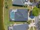 Aerial view of a property with a screened-in pool and well-kept lawn near a pond at 2487 Ridgemoor Dr, Orlando, FL 32828