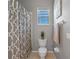 This streamlined bathroom offers a shower with patterned curtain, toilet, and functional towel rack at 2487 Ridgemoor Dr, Orlando, FL 32828