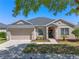 Charming single-story home with a two-car garage, landscaped yard, and inviting entrance at 2487 Ridgemoor Dr, Orlando, FL 32828