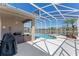 This screened-in pool offers a serene view with a built-in hot tub and outdoor kitchen area at 2487 Ridgemoor Dr, Orlando, FL 32828