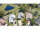 Aerial view of houses with well-maintained lawns, driveways, and proximity to a pond and road at 2511 Chatham Cir, Kissimmee, FL 34746