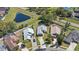 Aerial shot of three houses with well-manicured lawns, driveways, and proximity to a nearby pond and road at 2511 Chatham Cir, Kissimmee, FL 34746