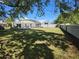 Expansive backyard view with a screened-in pool enclosure and lush green lawn at 2511 Chatham Cir, Kissimmee, FL 34746