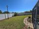 View of a meticulously maintained backyard featuring lush green grass, a stone walkway, and a pristine white fence at 2511 Chatham Cir, Kissimmee, FL 34746