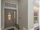 Close-up of the front door with sidelights and decorative window, surrounded by neutral gray siding at 2511 Chatham Cir, Kissimmee, FL 34746