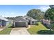 Inviting single-story home with manicured lawn, mature trees, and a two-car garage at 2511 Chatham Cir, Kissimmee, FL 34746