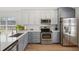 Well-lit kitchen featuring two-tone cabinetry, stainless steel appliances, and a modern backsplash for a sleek design at 2511 Chatham Cir, Kissimmee, FL 34746