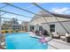 Spacious pool area with a screened enclosure, outdoor dining, and a fun flamingo float at 2511 Chatham Cir, Kissimmee, FL 34746
