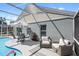 Inviting screened-in pool area with comfortable lounge seating and outdoor dining set at 2511 Chatham Cir, Kissimmee, FL 34746
